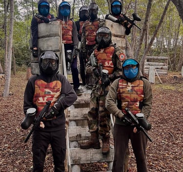 Groupe de joueurs équipés en tenue de paintball sur terrain boisé à Anghione en Corse 