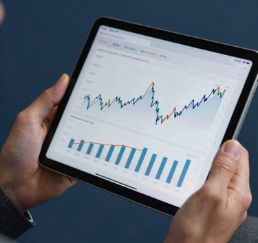 A professional in European Portuguese business attire holding a digital tablet showing financial performance indicators. Close-up on the hands and tablet, set against a dark blue background.