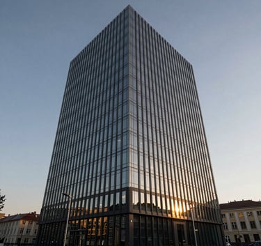 Wide shot of a sleek corporate office building in Bratislava, Central Europe, during golden hour with a clear grey blue sky and modern glass reflections.