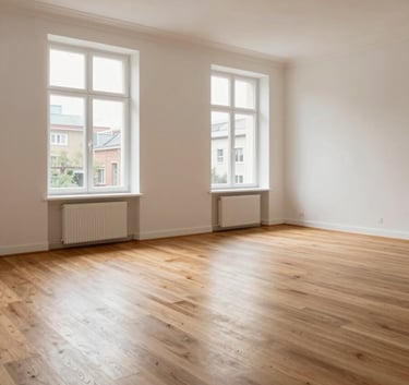 A bright, airy interior of a modern residential property in Berlin. The space is unfurnished, showing polished wooden floors and large windows. The lighting is natural, and the walls are a soft off-white, emphasizing efficient and clean property care.