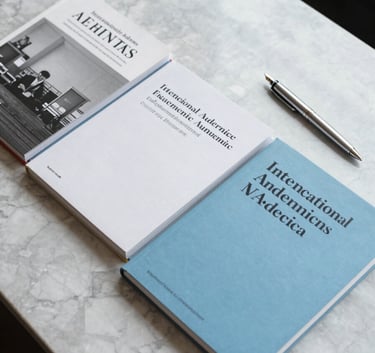 A top-down view of several high-end academic journals neatly arranged on a polished marble desk alongside a silver fountain pen in an International Academic setting. Bright, professional lighting. Palette: Soft Sky Blue and Crisp White.
