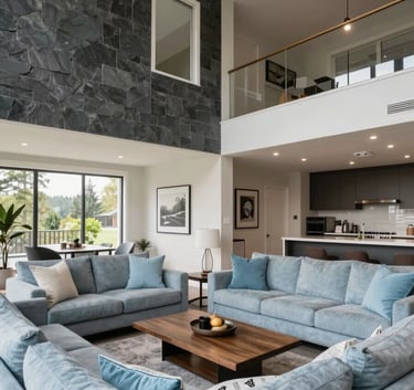 A wide-angle view of a beautifully renovated living room in a North American / Canadian (with South Asian cultural influence) home in Surrey. The room features high ceilings, dark slate grey accents, and soft sky blue cushions on a modern sofa.
