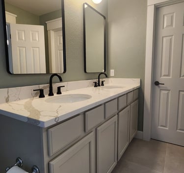Modern bathroom interior transformation showcasing freshly painted cabinets and soft sage green wall