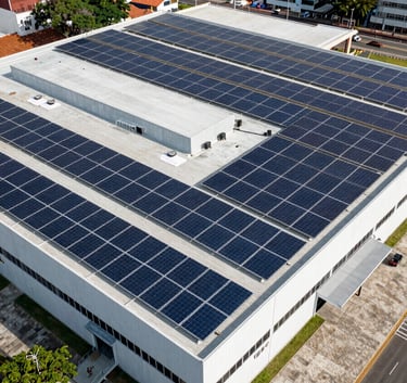 Aerial view of a large commercial installation of solar panels on the roof of a modern retail building in a Brazilian urban area, showcasing scale and industrial capability.