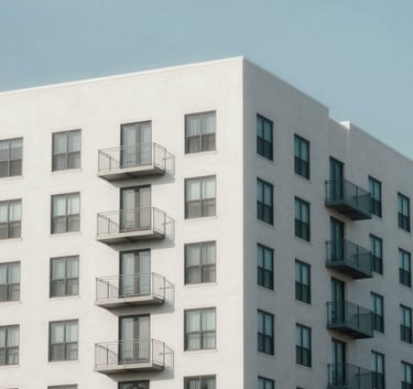 A professional wide-angle photograph of a modern multifamily apartment building in Central Florida. The architecture is clean arctic white against a clear soft misty blue sky. The composition emphasizes security and order.