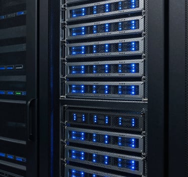 A sharp, eye-level photograph of a secure server room with blinking light grey and steel blue lights, representing modern technology and data privacy in a professional North American facility.