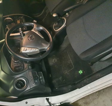 Przedni fotel z zaciekami i brudna tapicerka przed praniem.