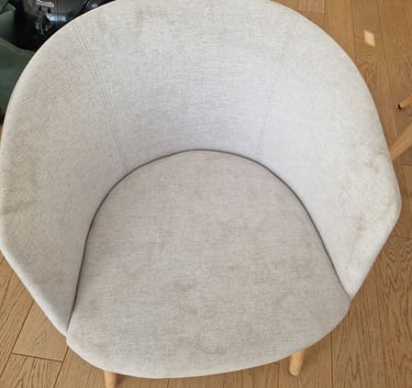 Poplamiony tapicerowany fotel przed praniem