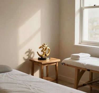A sophisticated and serene therapy room in Latin America, featuring minimal wooden furniture, a small golden Om sculpture on a side table, soft natural light, and a warm, inviting professional atmosphere.