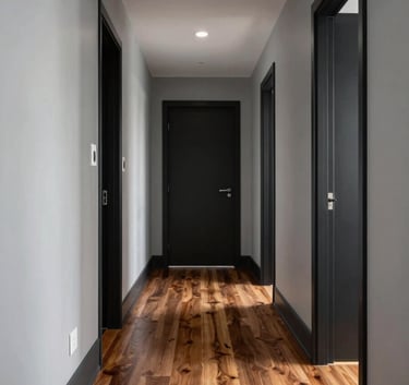 Professional photography of a renovated Australian hallway with light grey walls, dark charcoal accents, and high-quality timber flooring.