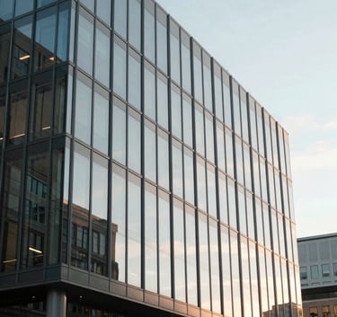 Clean, minimalist photography of the exterior of a modern glass office building in a North American city, soft morning light, reflecting a clear sky, professional and sophisticated atmosphere.