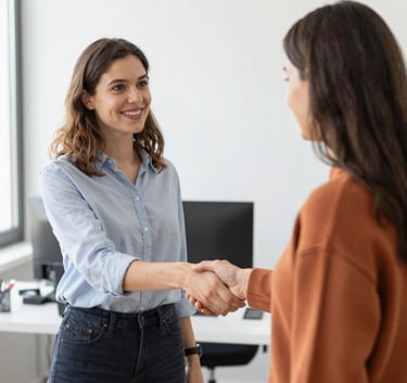 Professional business handshake between diverse colleagues in a modern office hallway.