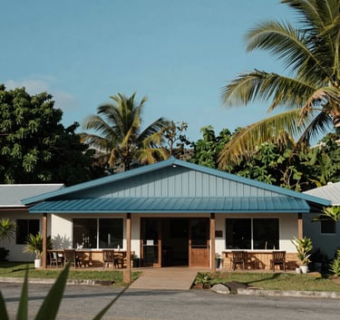 A modern and welcoming community building in a Central American / Costa Rican coastal setting, surrounded by tropical greenery and clear blue sky, composition is architectural and inviting, with Muted Blue accents.