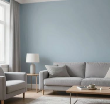 Interior shot of a living room with freshly painted walls in a soft blue-grey #B0BEC5. The finish is smooth and professional. Minimalist, modern furniture, soft natural lighting from a window.