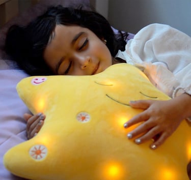 Little girl sleeping, holding her My Dua' star pillow by Desi Doll