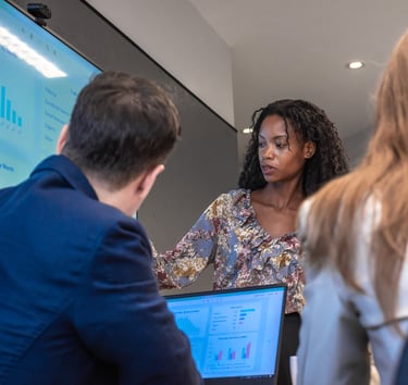 Woman presenting data on a screen to colleagues during a meeting.