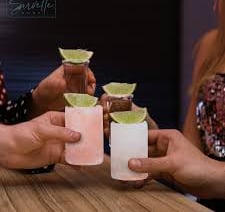 Salt shot glasses with lime held in a toast