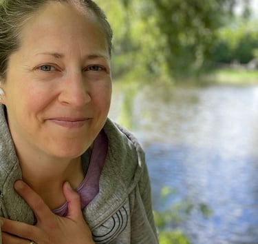 a woman with a gray jacket and a pink shirt