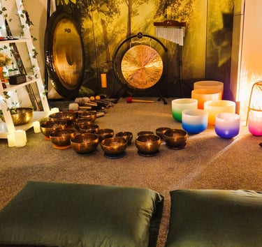 Studio with gongs and singing bowls on the floor in front of two pillows