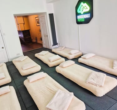 Two rows of four air beds laid on the floor with pillows and blankets