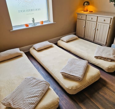 Three air beds on the floor with blankets and pillows