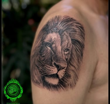 Detailed realistic tattoo of a lion's face on the upper arm