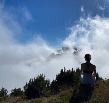 a woman in a white dress is standing on a hill