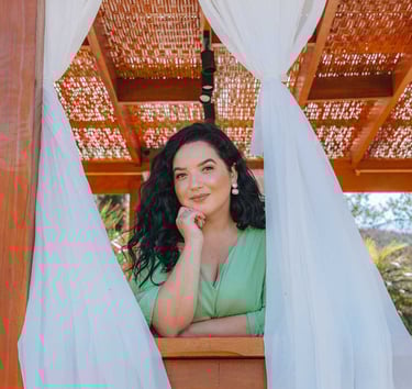 Raabe com meio sorriso entre duas cortinas brancas.