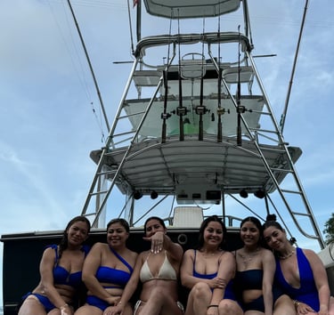 a group of women in bikinis sitting on a boat