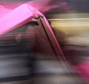Abstract motion blur featuring vibrant pink fabric folds with dramatic lighting and dark shadows.