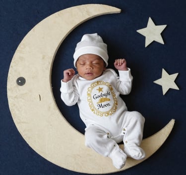 two imageNewborn baby sleeping on a handmade moon prop with stars for a celestial-themed photoshoot.