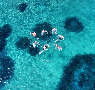 a group of people swimming in the ocean near la Canée
