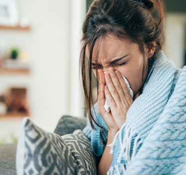 a woman in a blue sweater is holding a tissue paper towel