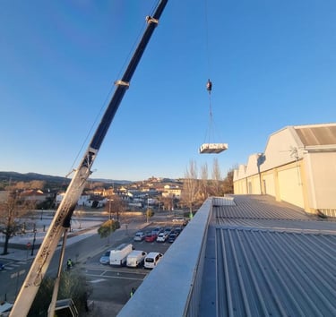grúa de AISPAM subiendo equipos a una azotea 