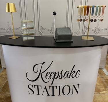Custom keepsake station booth with photo keychains, leather straps, and craft machinery.