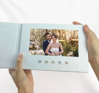 Hands holding a white digital video wedding album playing a romantic couple's ceremony movie.