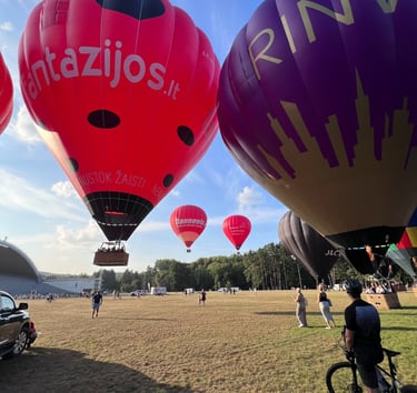 a man standing in front of a group of hot air balloons