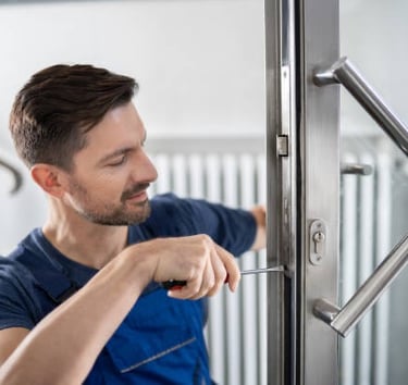 a man in a blue shirt is holding a door handle