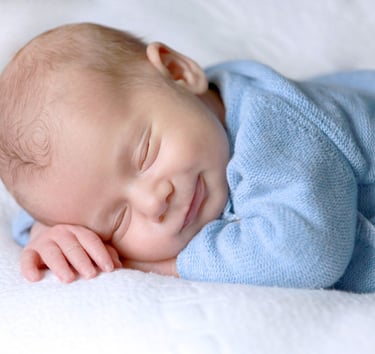un bébé heureux dort sur une couverture dans un lit