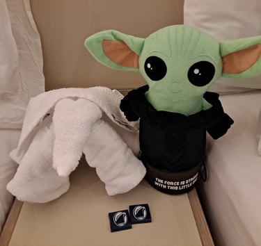 Little green companion and Towel elephant on night stand