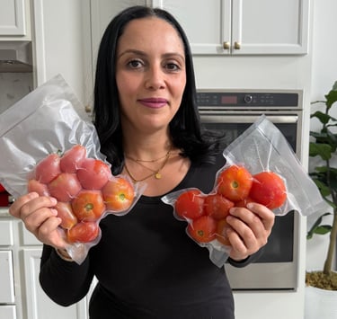 By eya holding a bag with whole frozen tomatoes 