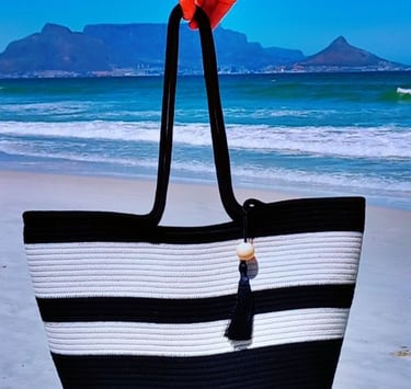 a person holding a black and white striped bag