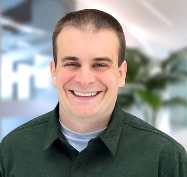 a man in a green shirt smiling at the camera