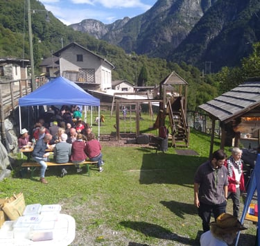 a group of people sitting at a table with food, pranzo in compagnia Menzonio, paella