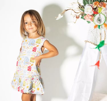 a little girl standing in front of a teepee