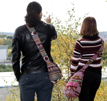 a man and woman standing on a hill overlooking a city