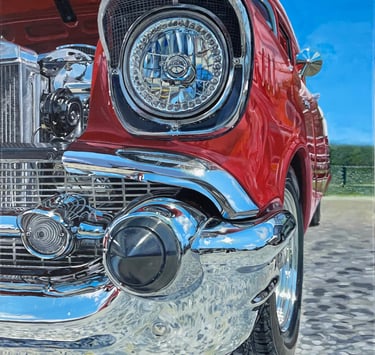 a close up of a red Chevy Bel Air car with a blue sky in the background