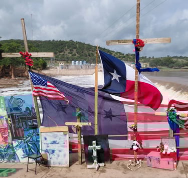 Flags and photographs displayed at a Kerrville, Texas flood memorial, July 4, 2025.