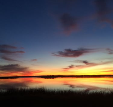 Sunrise colors reflected on a calm lake.
