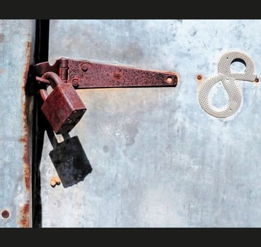 Rusty lock and number 8 on tin door